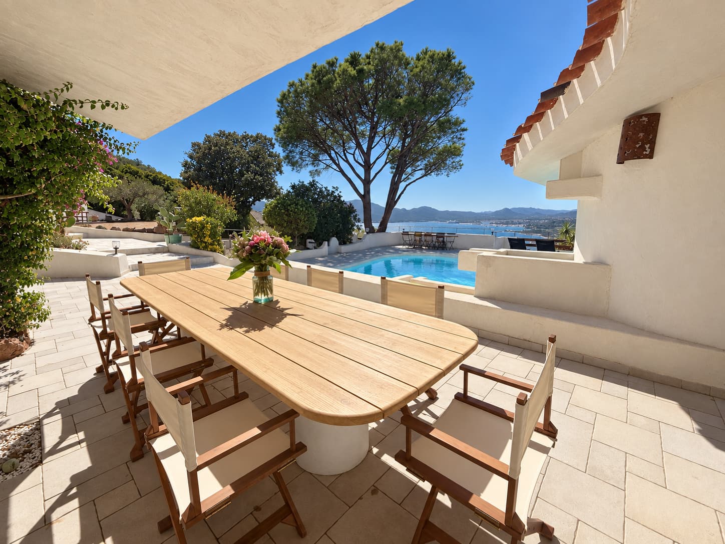 La longue table en teck sous la terrasse couverte, face à la piscine et au golfe, Domaine Diva